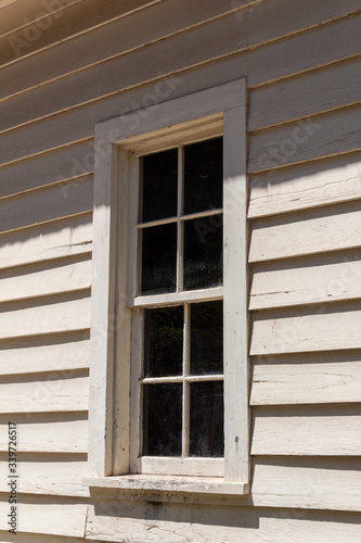 Eight pane window  four over four  in the wall of a clapboard house  vertical aspect