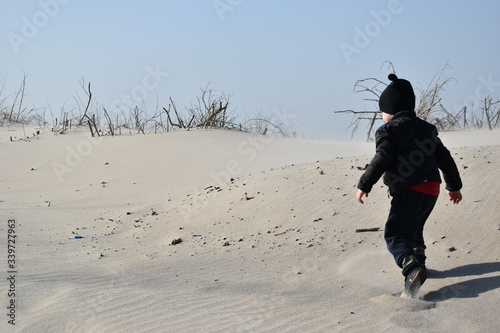 dziecko, plaża, wiosna, jesień, zabawa, słońce, hartowanie, czapka, kurtka, miki, czarny, piasek, radość, dzieciństwo, Kołobrzeg, wydmy, Morze Bałtyk, morze, bałtyckie,  spacer, pustynia, 