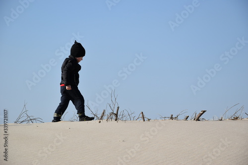 Obraz na płótnie dziecko, plaża, wiosna, jesień, zabawa, słońce, hartowanie, czapka, kurtka, miki, czarny, piasek, radość, dzieciństwo, Kołobrzeg, wydmy, Morze Bałtyk, morze, bałtyckie, spacer, pustynia, w salonie