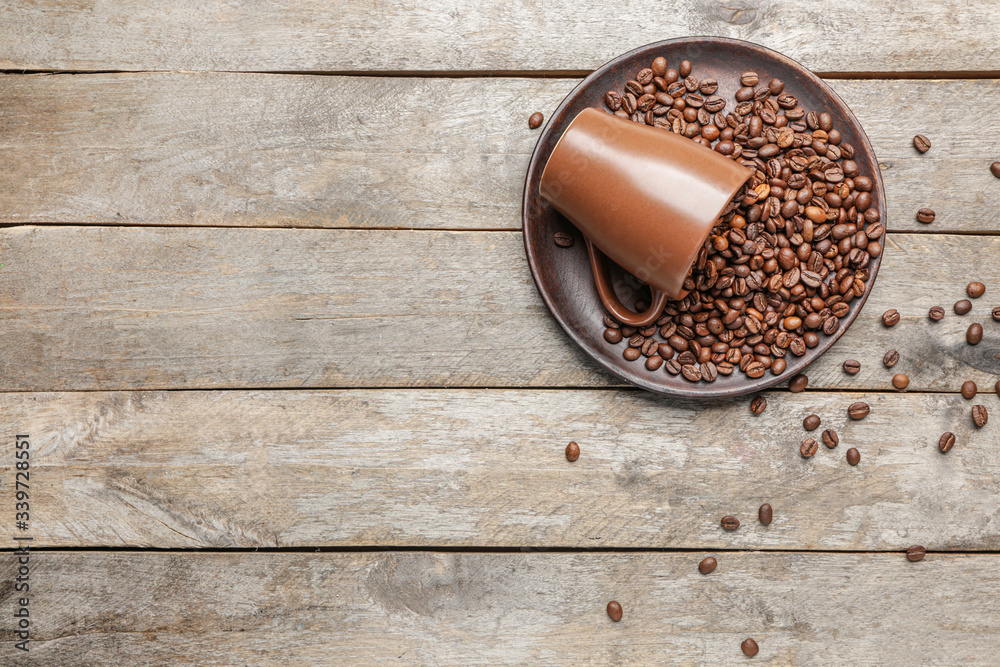 Cup and plate with coffee beans on wooden background Cup and plate with coffee beans on wooden background