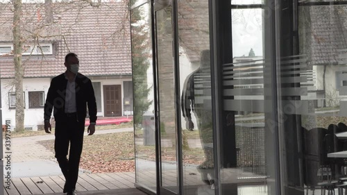 Wallpaper Mural Pandemic, A man in a protective mask near a closed cafe with large glass winds. Torontodigital.ca