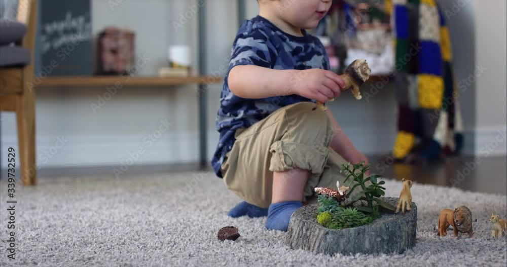 Boy playing with toy animals on floor stands up to talk to parents - close up Boy playing with toy animals on floor stands up to talk to parents - close up