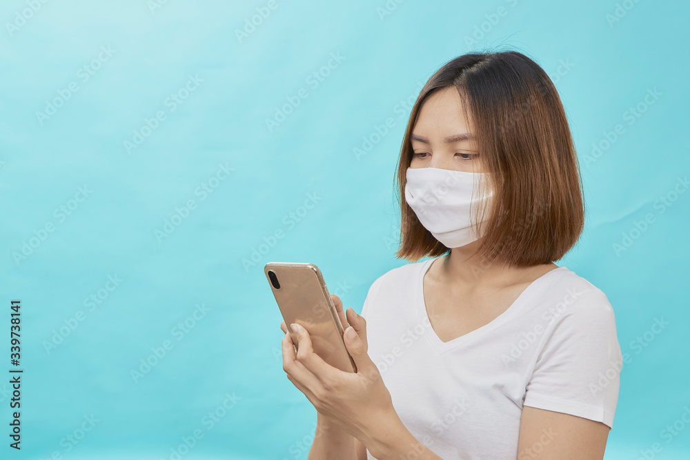 Woman wearing mask while standing using phone