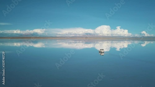 Drone Footage of a car driving at Salar De Uyuni salt flat just before sunset, Blue Hour