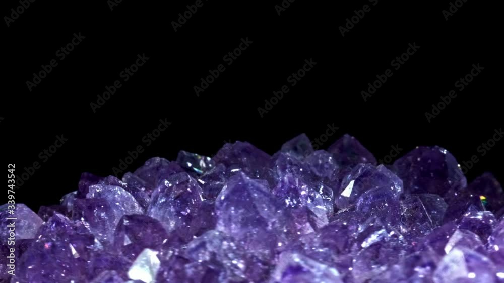 Seamlessly rotating a purple mineral (Amethyst) in front of black background.