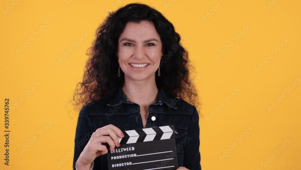 Portrait of beautiful young woman with black curly hair clapping a ...