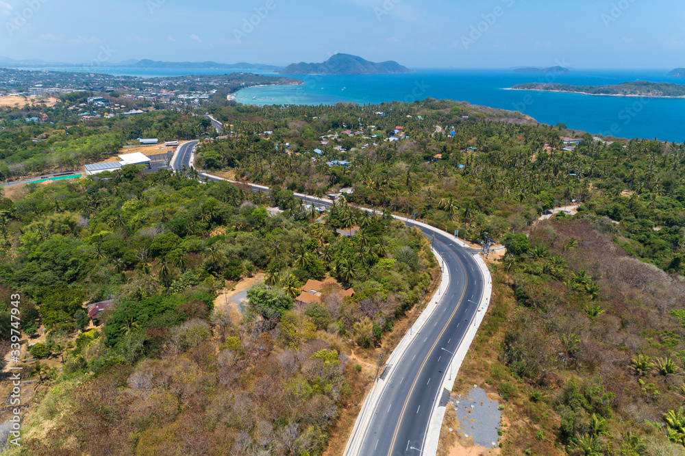 Asphalt rural road curve on high mountain with tropical sea in phuket Thailand image by Drone camera High angle view.