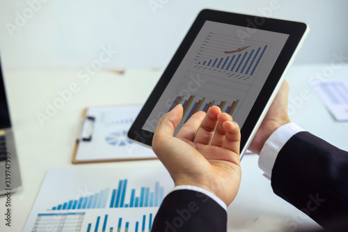 Business man supervising and secretary to execute business plan and consultant analyzing company annual financial report balance sheet statement working with documents graphs. Audit and consultant