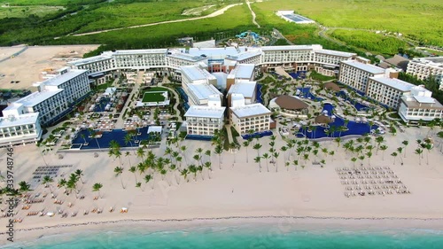 Luxury hotel on tropical island, white sand beach with palm trees and turquoise blue ocean, exotic vacation getaway, indyllic aerial panoramic scene photo