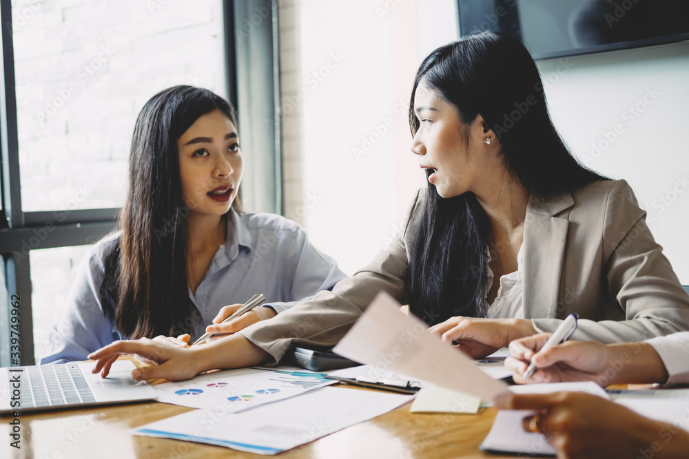 Asian business people meeting with new startup project pointing graph discussion and analysis data charts and graphs.Business finances and accounting concept Asian business people meeting with new startup project pointing graph discussion and analysis data charts and graphs.Business finances and accounting concept