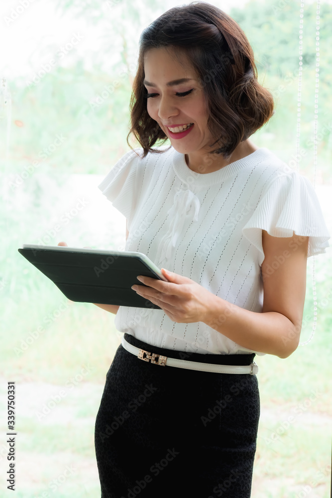 Portrait of beautiful young woman working with documents at office while talking on phone in the office. Portrait of beautiful young woman working with documents at office while talking on phone in the office.