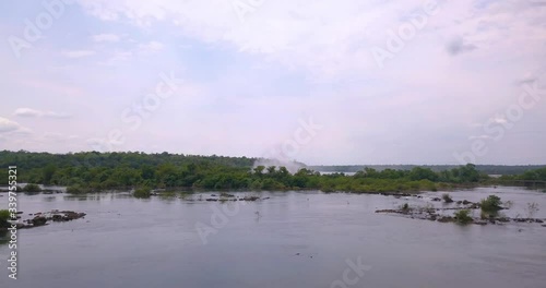 Flying Above Iguazu River With Famous Waterfalls and Water Mist in Background, Brazil Argentina Border, Drone Aerial View photo