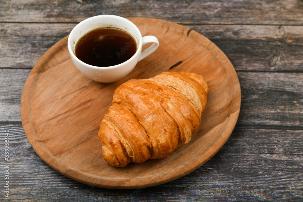 breakfast with croissant. the beginning of the morning. Fresh french croissant. Coffee cup and fresh baked croissants on a wooden background. View from above. Morning breakfast with croissant and coff