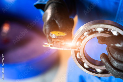 Engineer technician measure a ball bearing with vernier caliper, engineering Engine manufacturing factory Industry. Industrial Concept 
