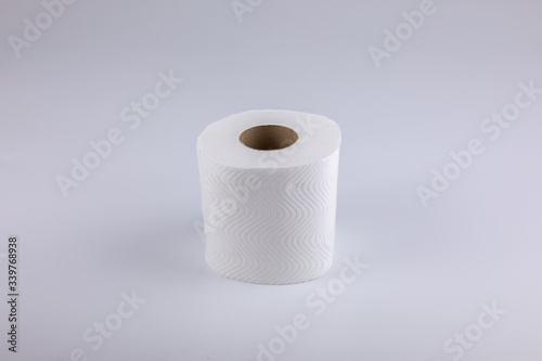 The unused white tissue roll was taken in a studio shot on a white background, with detailed details on the surface, the waves and perforations looking soft and providing comfort to users.