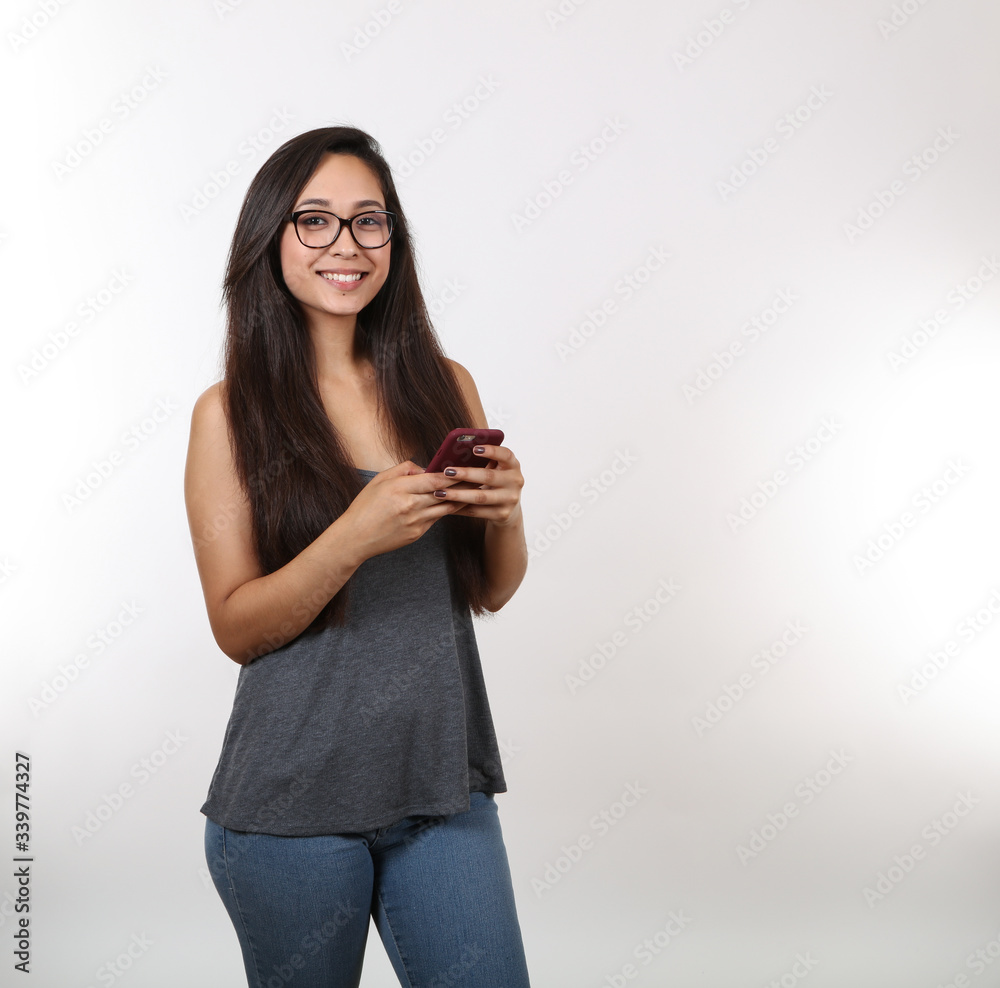 Young Lady in Grey Shirt and Glasses Holds Phone Young Lady in Grey Shirt and Glasses Holds Phone