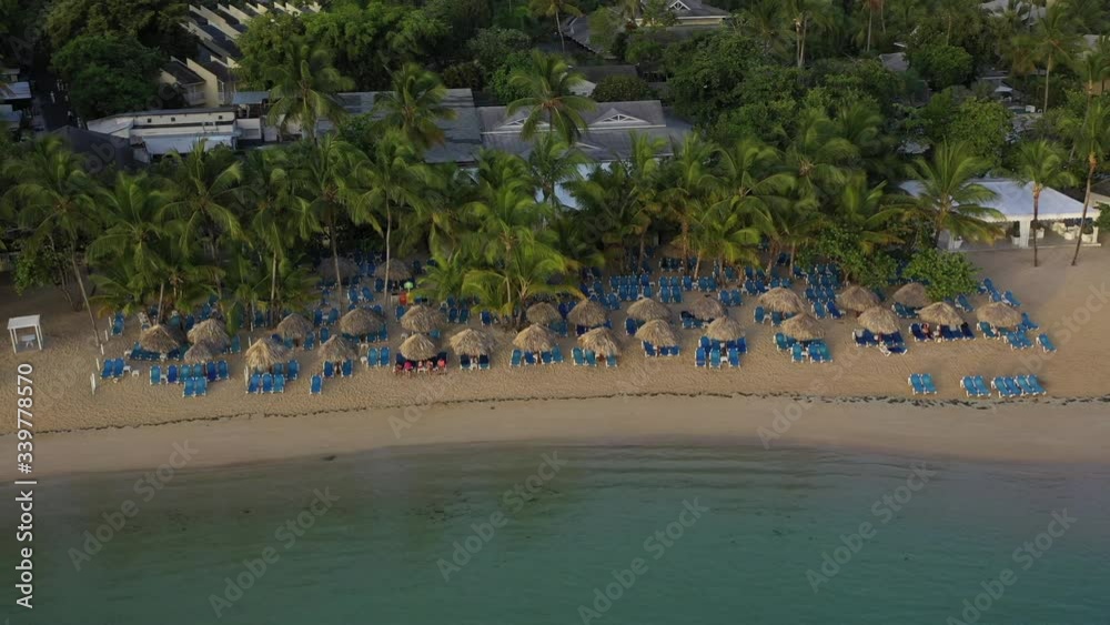 Drone view of ocean,boat,parasols and sandy Caribbean beach at sunrise,Grand Bahia Principe beach at Samana peninsula,Dominican republic. Drone view of ocean,boat,parasols and sandy Caribbean beach at sunrise,Grand Bahia Principe beach at Samana peninsula,Dominican republic.
