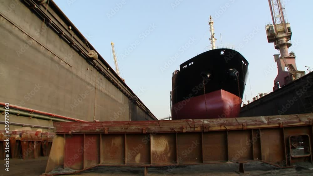 A dolly/pedestal up shot of an oil supertanker in dry dock. Crane shot