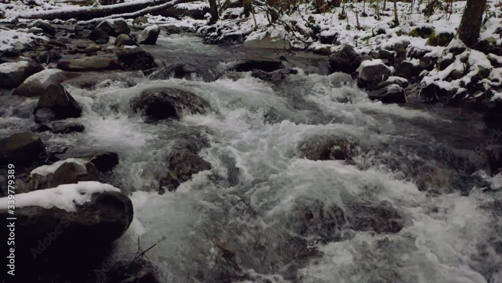 Aerial smooth flight from violent burrowing water mountain river in winter forest Aerial smooth flight from violent burrowing water mountain river in winter forest