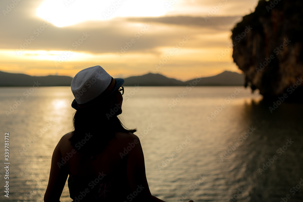 Luxury tourism vacation concept. Selective of focus  silhouette happy woman looking at blurry background view of ocean and tropical islands from sailing yacht during golden sunset.
