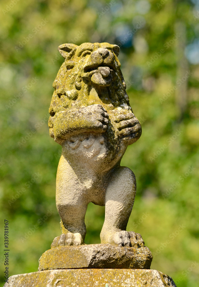 Vintage garden statue of a lion standing upright like a human.  Closeup.
