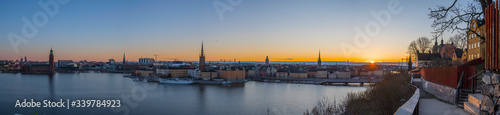 Morning view at sunrise over the districts of old town Gamla stan and the Djurgården with orange skyline with silhouettes a sunny morning in Stockholm from the district of Södermalm.