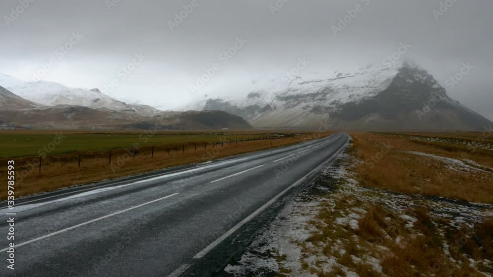 Empty country road in Iceland in a beautiful landscape with snowy mountains in the background Empty country road in Iceland in a beautiful landscape with snowy mountains in the background