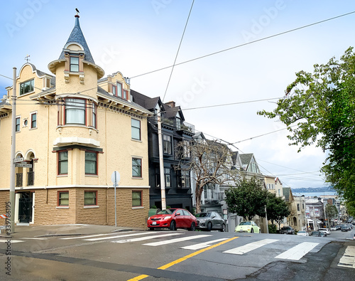 Canvas Print A light yellow victorian style building with turret roof followed by black building