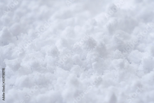 Background of fresh white snow. Winter snowflakes texture. Snow white texture winter background. Icy surface pattern. Shiny snow with bokeh. Macro shot