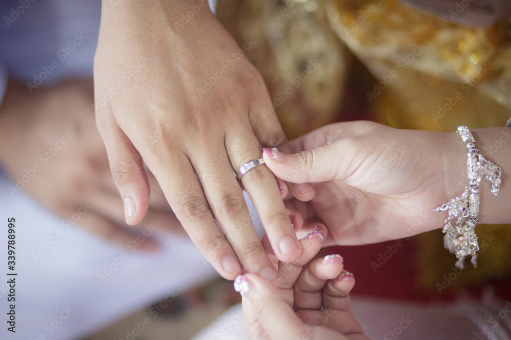 groom wears ring on bride's finger in wedding ceremony
