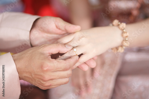 groom wears ring on bride's finger in wedding ceremony