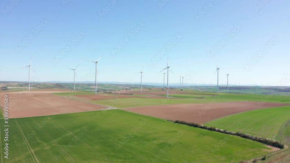 Rotating wind power plant producing renewable green clean engergy electricity, drone aerial panorama shot, 30p