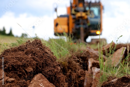 Soil on the Trench for a cable .CRAWLER EXCAVATOR Works on digging . blurred	 photo