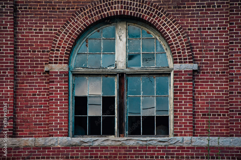 Arch broken glass window on brick wall