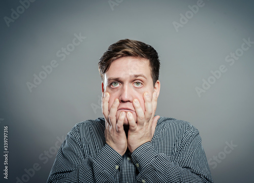 a young man upset with hands on face