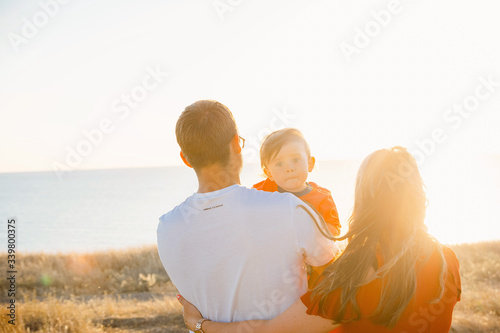 Young average family of three on vacation by the sea