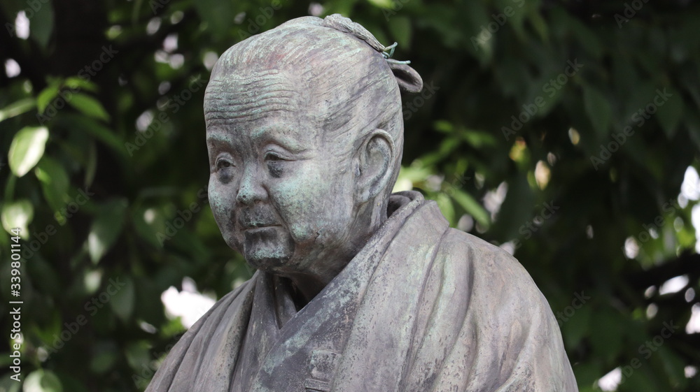 A stone statue of a grandmother sitting down