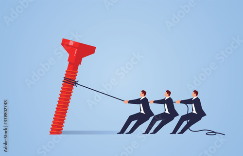 Three businessmen work together to pull out huge nails