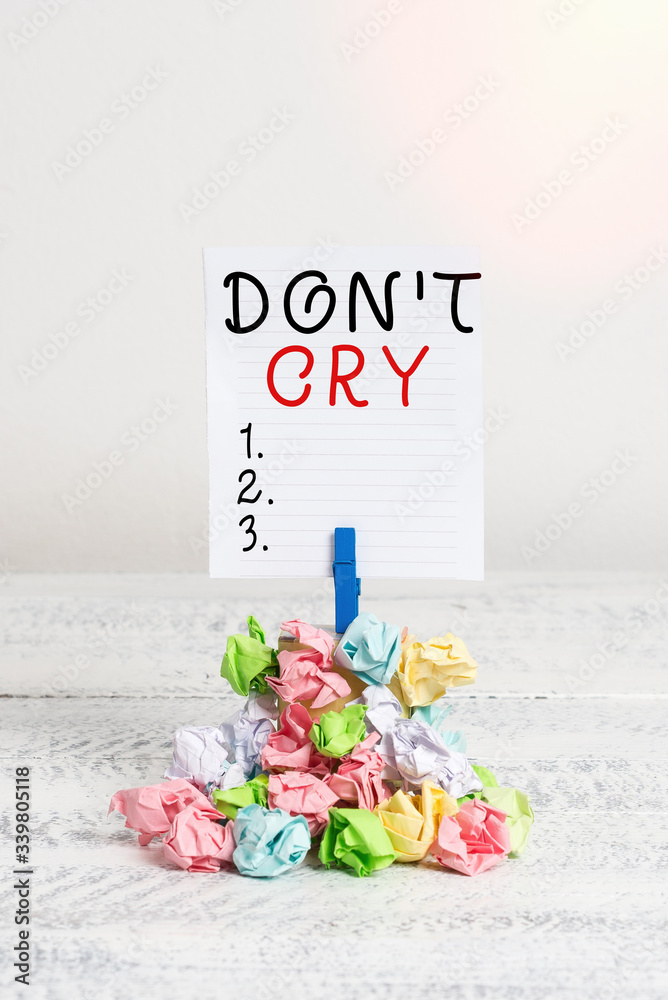 Conceptual hand writing showing Don T Cry. Concept meaning Shed tears  typically as an expression of distress pain or sorrow Reminder pile colored  crumpled paper clothespin wooden space Stock Photo