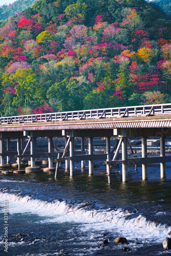 紅葉シーズンの京都嵐山、紅葉した山肌と渡月橋