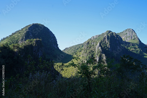 Natural landscape of green rocky mountain range with clear blue sky