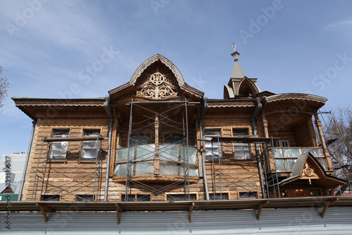 Wooden Shadrin's house with carved windows on Krasnoarmeysky Avenue, 8, in Barnaul city, Russia. Russian folk, art nouveau style in architecture. Barnaul landmark photo