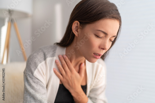 COVID-19 breathing difficulties woman with shortness of breath Coronavirus cough breathing problem. Asian girl in pain touching chest respiratory symptoms fever, coughing, body aches.