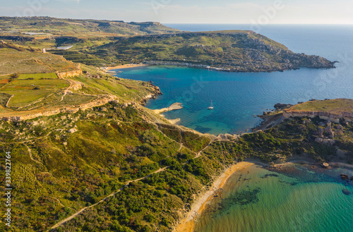 Aerial view of famous Ghajn Tuffieha beach and hills. Sunset time, nature landscape. Malta 