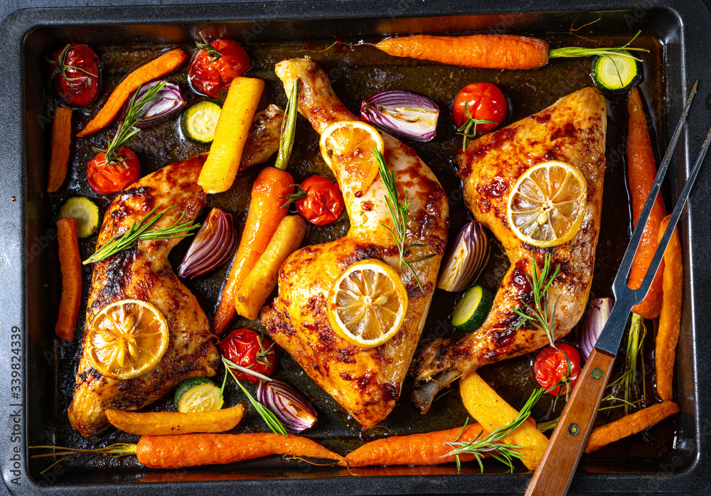 Grilled chicken legs with various vegetables and herbs.