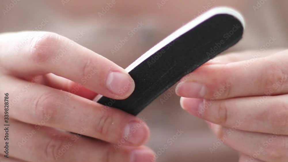 Close up of woman polishing fingernails with the nail file. Body care, manicure Close up of woman polishing fingernails with the nail file. Body care, manicure