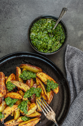 Obraz na płótnie Kartoffelspalten mit Pesto aus Kohlrabiblättern auf einem dunklen Hintergrund w salonie