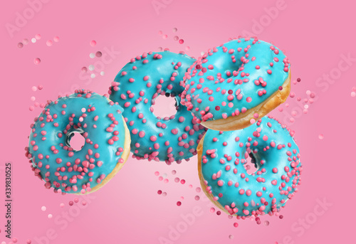 Set of falling delicious donuts on pink background
