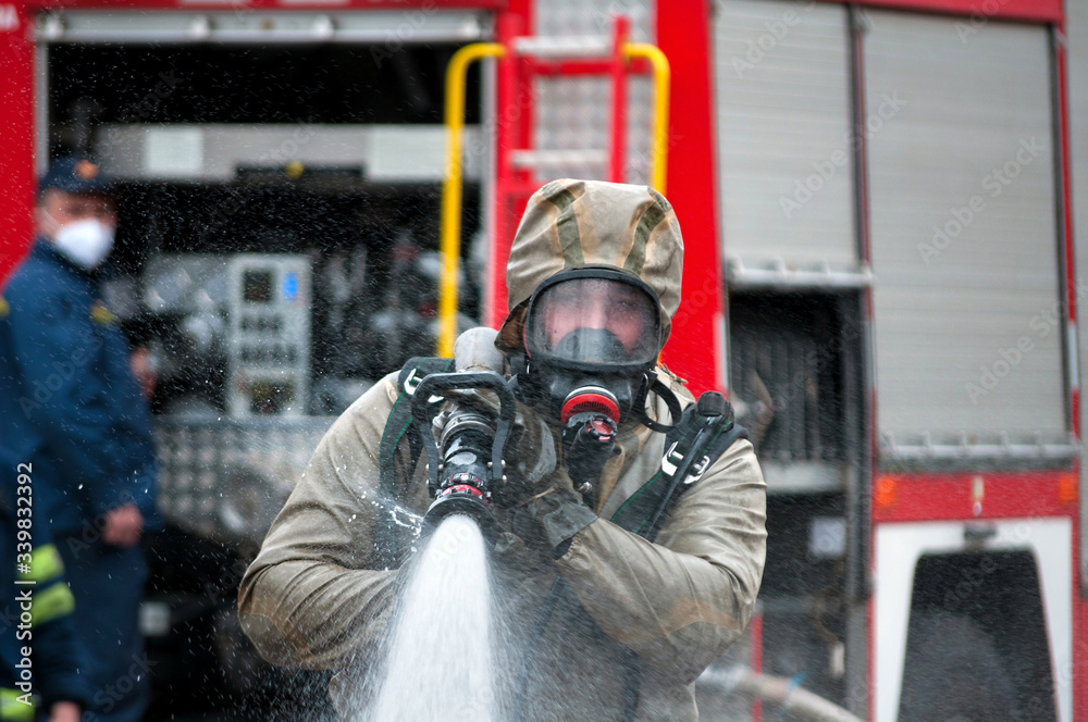 Obraz premium rescue team disinfecting street with special decontaminating liquid solution while covid disaster from fire engine