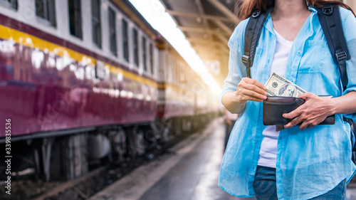 Young woman backpacker traveler hands holding wallet dollar currency money plan to saving spend budget for holiday buy cheap discount deals travel promotion trip after coronavirus empty tourist crisis